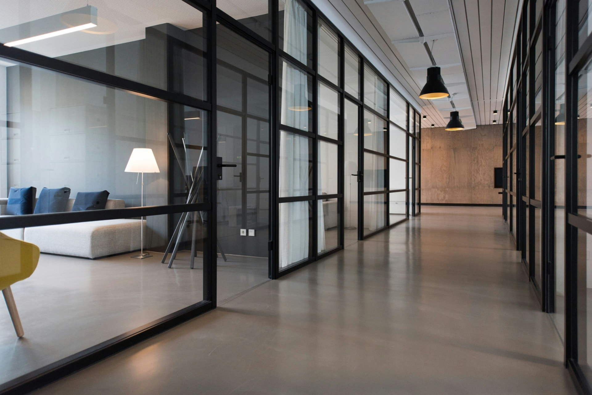 Büroflur mit Glaswänden und Lounge-Bereich